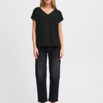 Woman wearing a black top and black pants on a white background