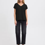 Woman wearing a black top and black pants on a white background